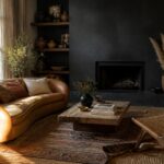 Cozy room with curved brown leather sofa, patterned rug, dark fireplace, and wooden table.