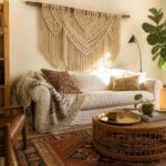 Cozy bohemian living room with white sofa, macrame wall hanging, rattan table, and patterned rug.