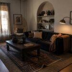 Cozy living room with navy sofa, hanging rattan chair, arched shelves, and plants